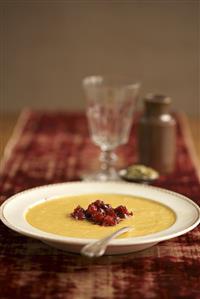 Bowl of Pumpkin Soup Topped with Chunky Cranberry Sauce