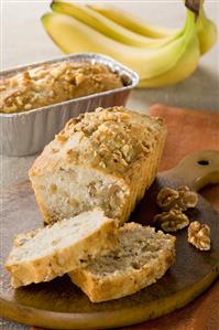 Partially Sliced Banana Nut Loaf Cake; On Cutting Board and Pan