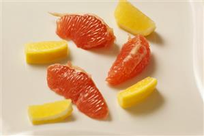 Peeled Grapefruit Sections and Lemon Slices on White Background