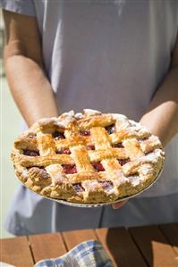 Person Holding Lattice Top Cherry Pie