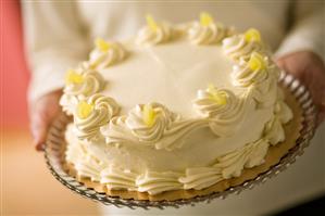 Woman Holding Whole Lemon Curd Cake