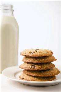 Chocolate Chip Cookies Stacked on Plate; Bottle of Milk