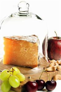 Wedge of Cheddar Cheese under Bell Jar with Fruit and Nuts