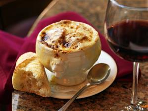 Bowl of French Onion Soup with Bread and Red Wine