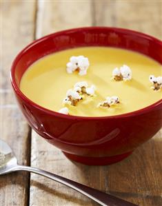 Bowl of Cheddar Cheese Beer Soup with Popcorn Garnish