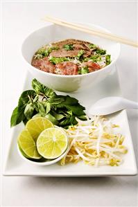 Pho; Vietnamese Sliced Meat and Rice Noodle Soup in Bowl with Chopsticks