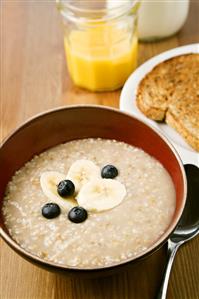 Bowl of Irish Oatmeal with Bananas and Blueberries; Toast and Juice