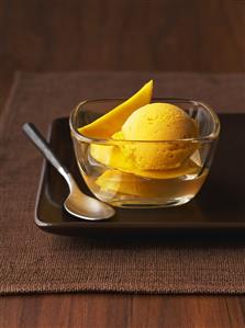Scoop of Mango Ice Cream with Mango Slices and Syrup