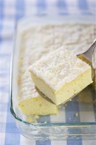 Lifting a Piece of Lemon Buttermilk Sheet Cake from Pan