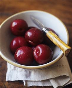 Freshly Washed Plums in a Bowl with Knife