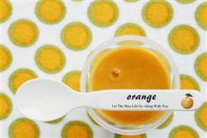 Orange dessert in small bowl with spoon