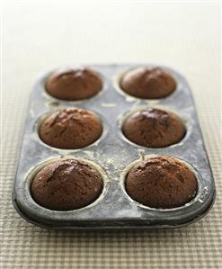 Six chocolate muffins in a muffin tin