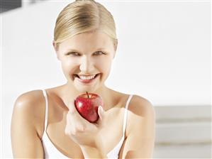 Woman with red apple outdoors