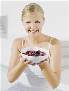 Woman outdoors with bowl of cherries