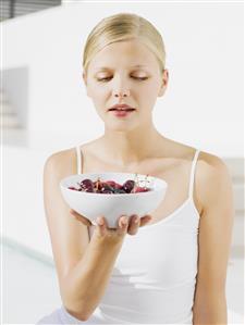 Woman outdoors with bowl of cherries