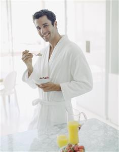 Man in bathrobe with healthy breakfast smiling