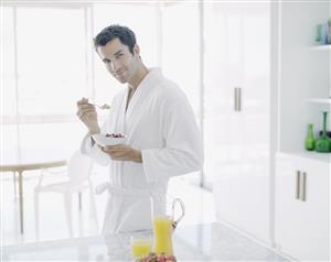 Man in bathrobe with healthy breakfast smiling