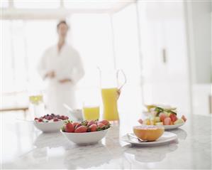 Man in bathrobe with fruit berries and orange juice