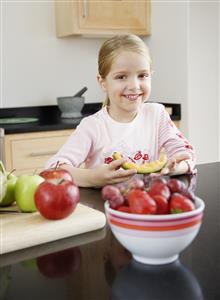 A young girl eating melon