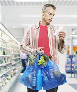 Man looking at bill in grocery store