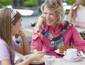 Woman and young girl on outdoor patio eating meal