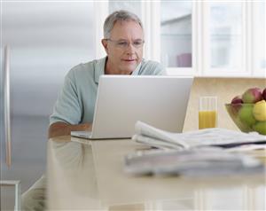 Man in kitchen using laptop