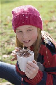 Young girl outdoors holding hot chocolate