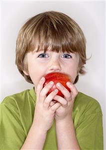 Young boy eating apple