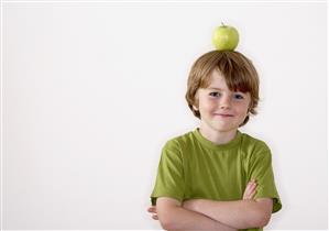 Young boy balancing apple on his head