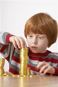 Young boy in kitchen piling up chocolate gold coins