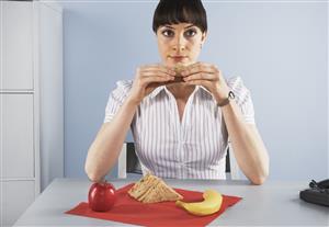 Businesswoman eating healthy lunch at desk