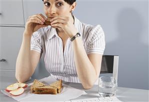 Businesswoman eating healthy lunch at desk