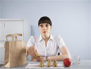 Businesswoman eating healthy lunch at desk