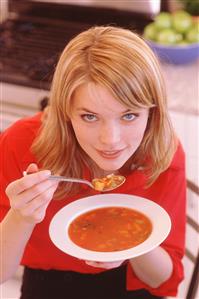 Mujer comiendo un plato de sopa. Primer plano.