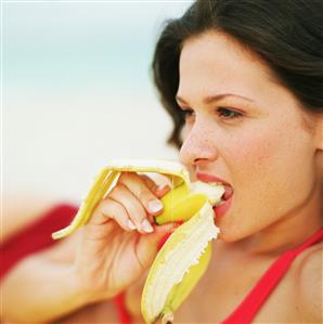 Mujer comiendo un platano. Primer plano.