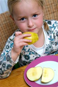 Niña comiendo una manzana. Primer plano.