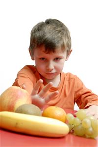 Niño rechazando la fruta.