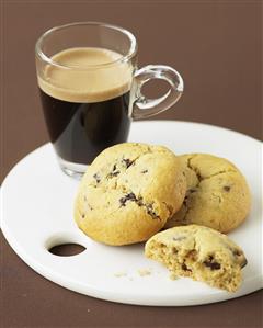 Cookies de chocolate con frutos secos y taza de cafe. Receta disponible.
