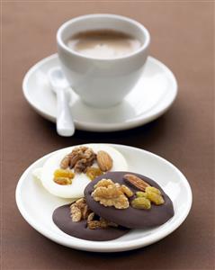 Galletas de chocolate negro y chocolate blanco con frutos secos y taza de cafe. Receta disponible.
