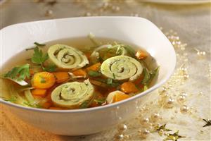 Caldo de pollo con tortilla, zanahorias y perejil. Receta disponible.
