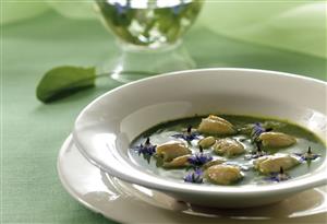 Sopa verde con ancas de rana y flores. Receta disponible.