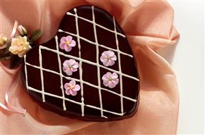 Corazon de chocolate y marron glace adornado con flores. Receta disponible.