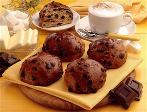 Bollitos de boniato con grageas de chocolate y taza de cafe con leche.