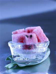 Sandia, cortada en dados, sobre hielo.