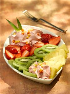 Plato con fresones, kiwis, piña y crema rosa. Receta por encargo.
