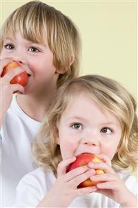 Boy and girl eating apples