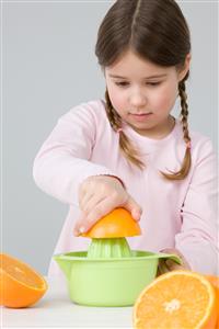 Girl juicing oranges