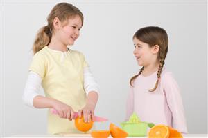 Girls cutting oranges