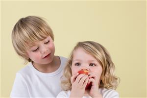 Boy and girl eating apple