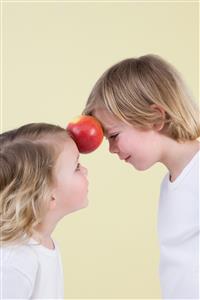 Boy and girl with apple between them